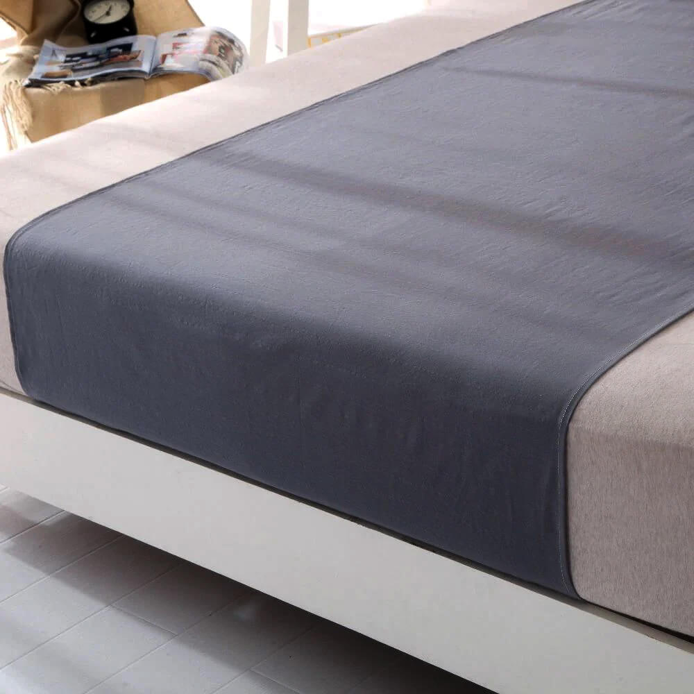 Bedroom with neatly made bed and grounding therapy blanket.